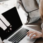 Creative Entrepreneurs - Close-up Photography of Woman Sitting Beside Table While Using Macbook