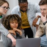 Entrepreneurs - A Group of People Planning while Looking at the Laptop