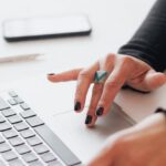 Turnaround Strategies - Crop female using touchpad on laptop in office