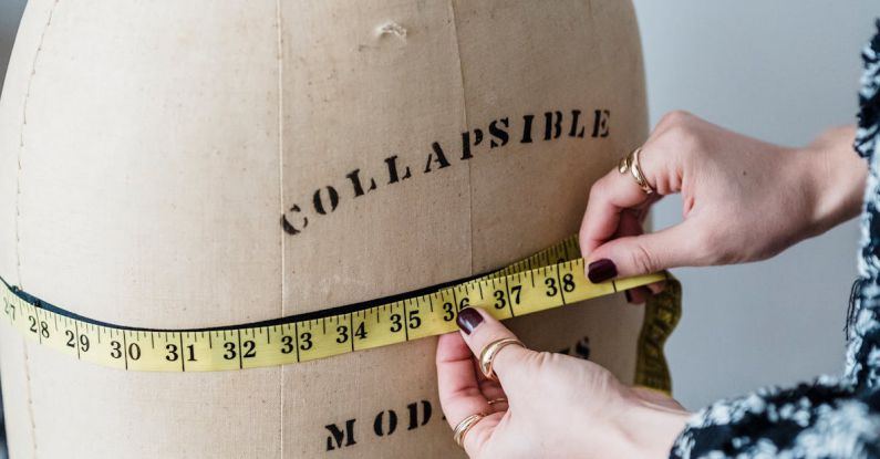 Flexible Work - Crop unrecognizable female dressmaker with flexible ruler measuring hip line of dummy while working in studio