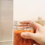 Ethical Business - Person Holding Clear Glass Jar With Brown Substance