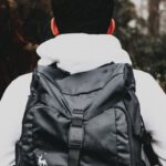 Brand Image - Faceless male tourist with stylish rucksack in foggy forest