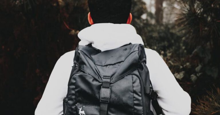 Brand Image - Faceless male tourist with stylish rucksack in foggy forest